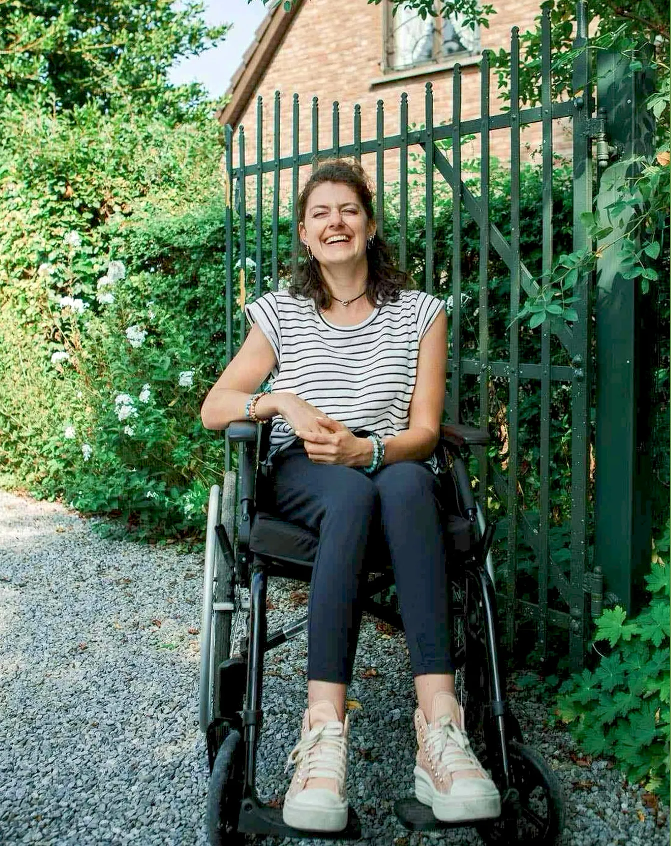 Margaux, souriante, devant une grille de jardin