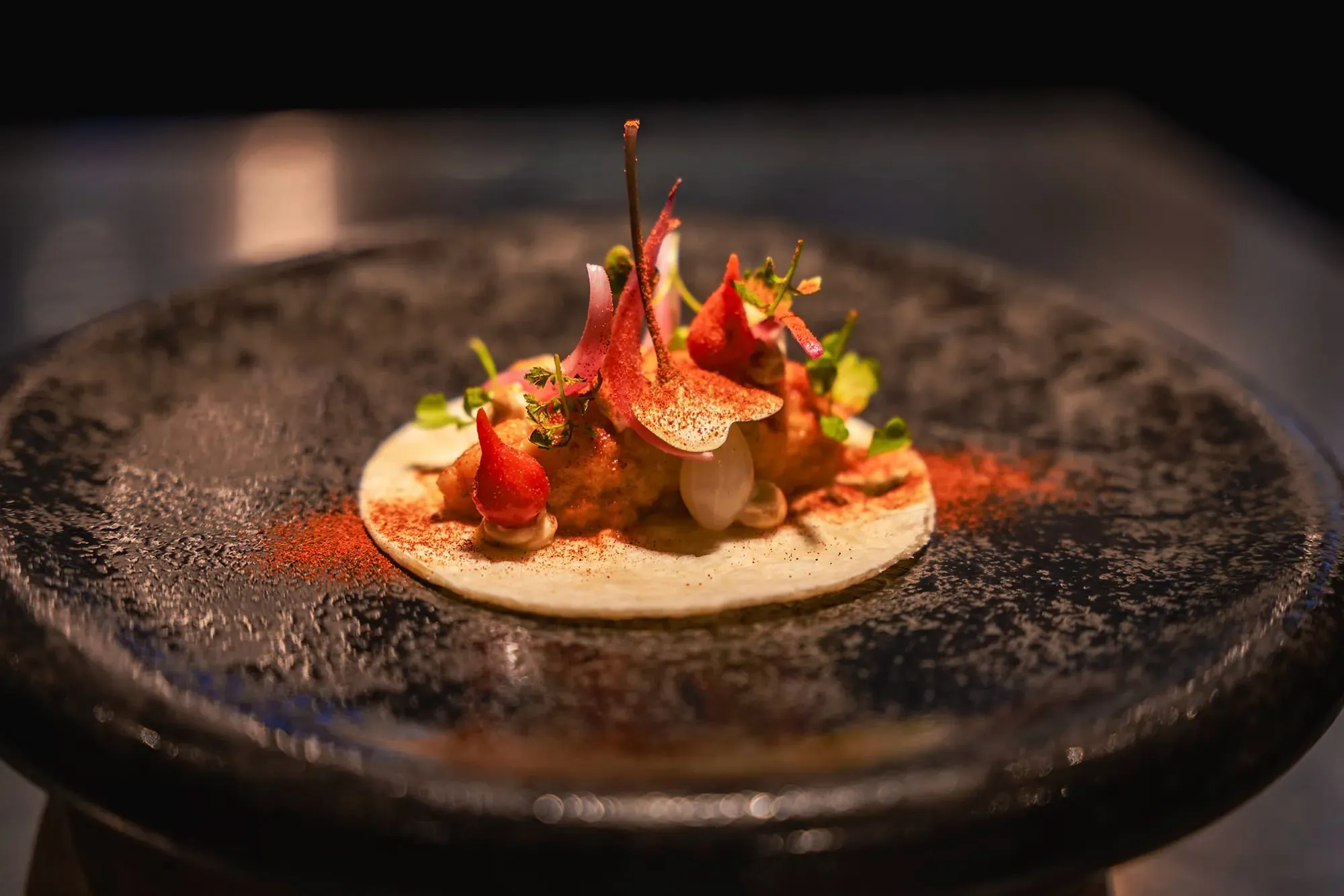 Assiette dressée sur une table sombre au restaurant Olivier Massart